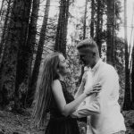 A joyful couple embracing in a grayscale forest, capturing their genuine happiness.
